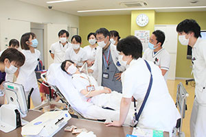 デモンストレーションでは、千木良さん自らの頸静脈が供覧できるように指導医師と共働する。