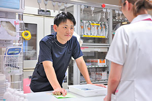 ナースステーションで、先輩と一緒に薬剤の確認作業を行う。3年目になった現在、自身も先輩として、新人のサポーターの役割を担っている。